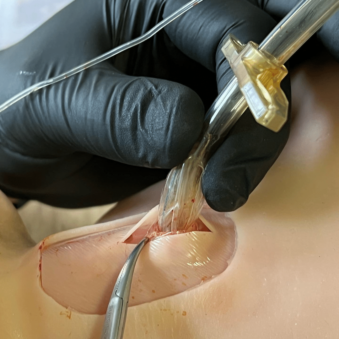 Close up of a tube being inserted during a CRIC surgical airway training exercise in the classroom